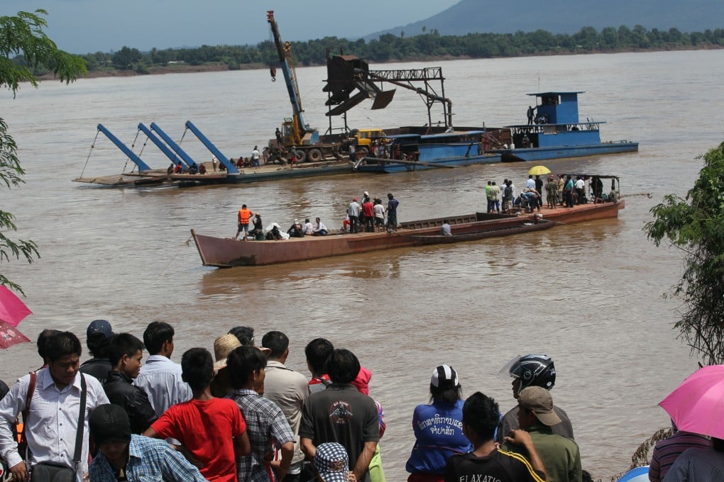 Onlookers watch the search operation for the lost Lao Airlines plane on the banks of the Mekong River in Pakse, Laos, on Thursday. Photo: AP