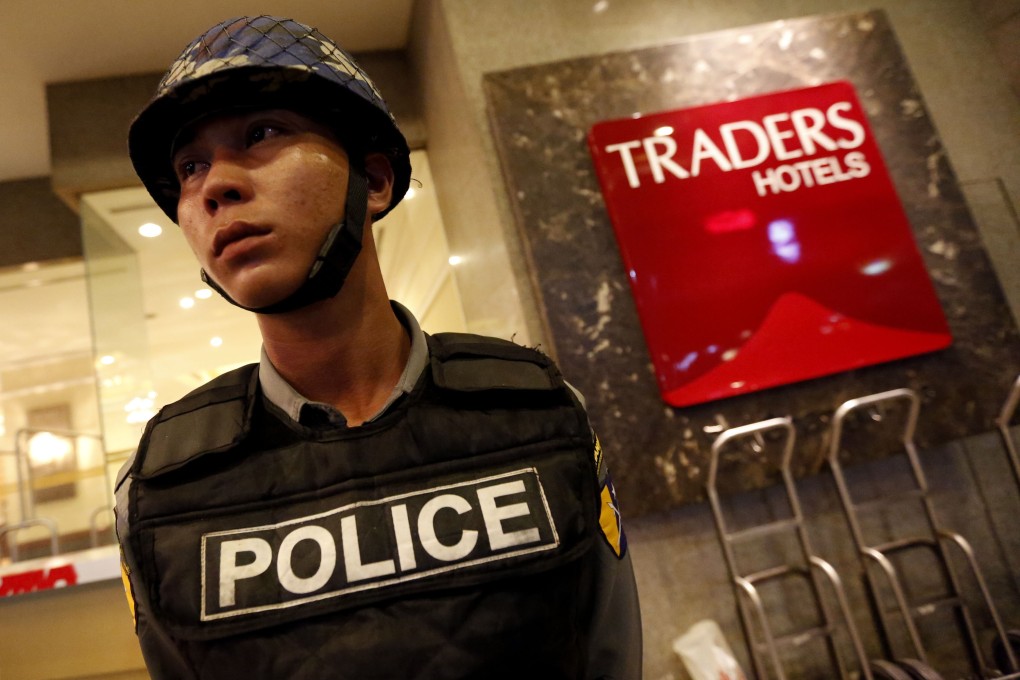 A policeman stands guard in front of the Traders Hotel in Yangon, Myanmar, after an explosion. Photo: Xinhua