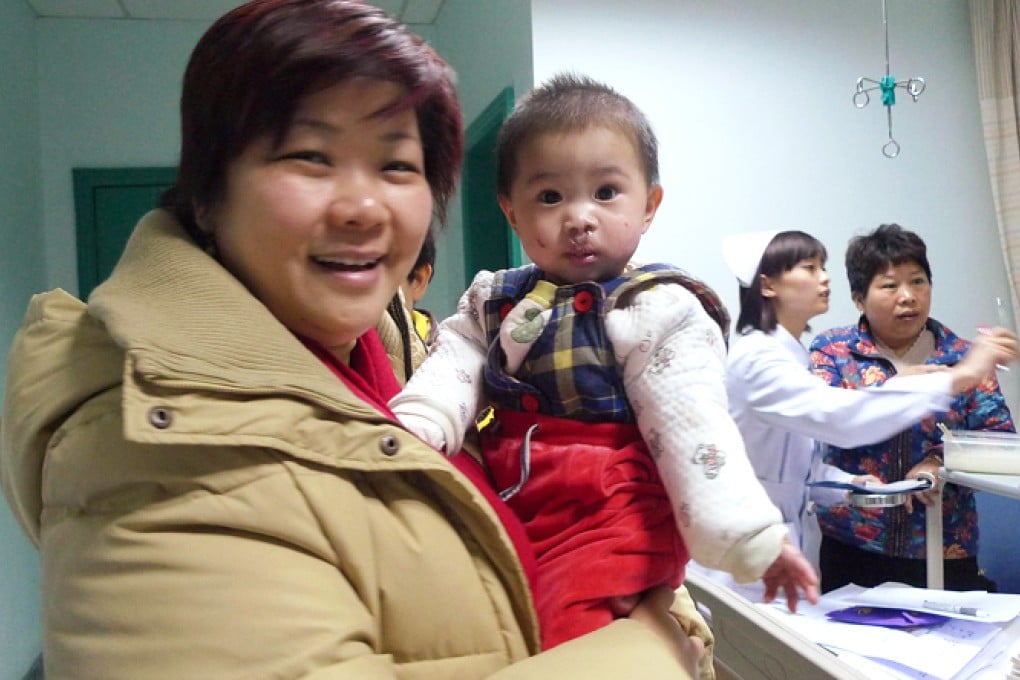Elana Ho holds an orphan baby following surgery at a mainland hospital to correct his cleft palate. Photo: SCMP