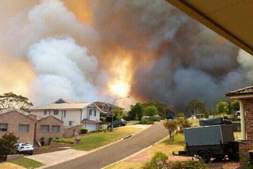 A bush fire threatens homes yesterday in Springwood, New South Wales, where more hot weather beckons. Photo: EPA