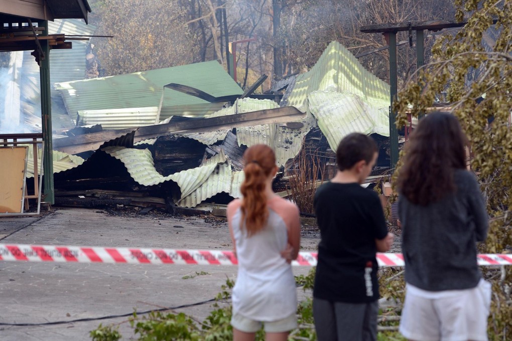 Children look at a burned house in Winmalee. Photo: AFP