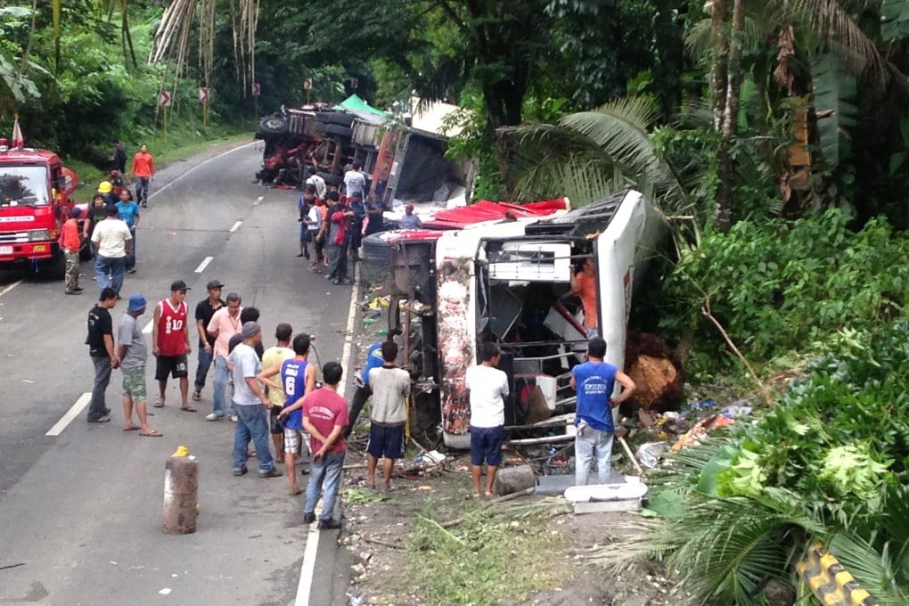 Filipino villagers view a wrecked passenger bus and a truck on a side of a road following an accident in the town of Atimonan, Quezon province, Philippines. Photo: EPA