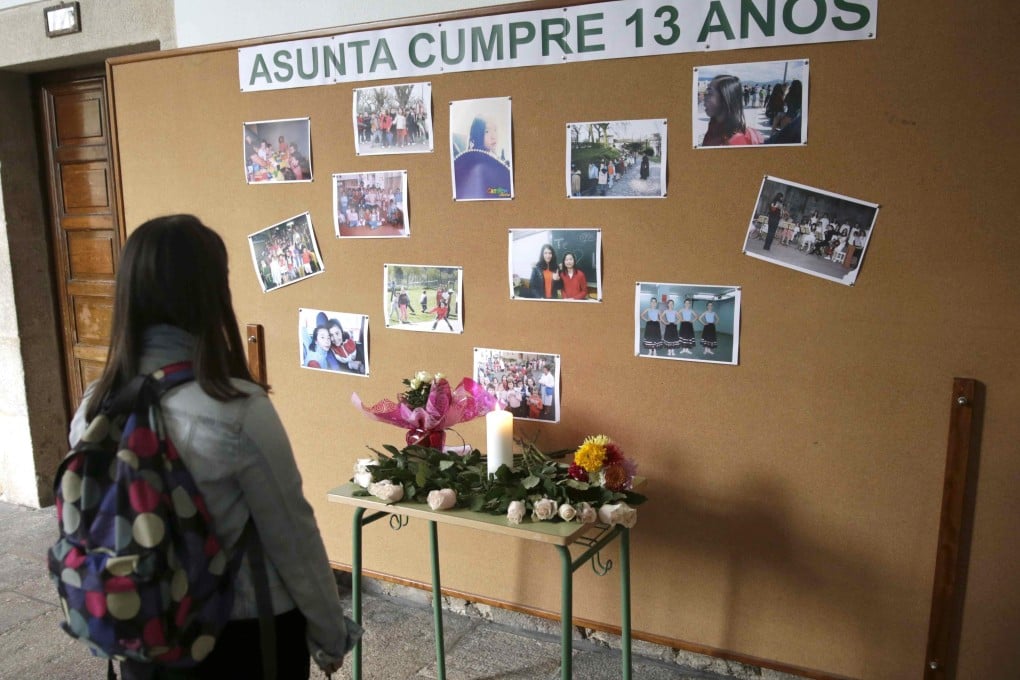 A girl looks the mural with pictures of Asunta Basterra, the 12-year-old girl of Chinese origin who was found dead on 22 September. Photo: EPA
