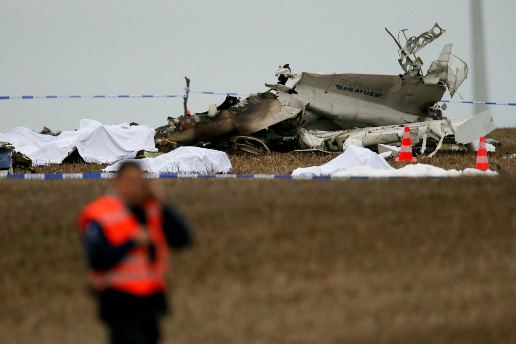 Covered victims' bodies lie near pieces of the plane. Photo: EPA