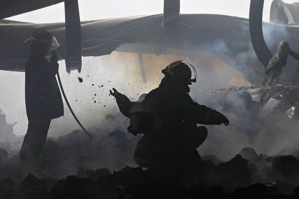 Bangladeshi firefighters at the scene after a fire at a garment factory in Sripur. Bangladesh is launching a safety campaign to overhaul conditions at garment factories. Photo: AFP