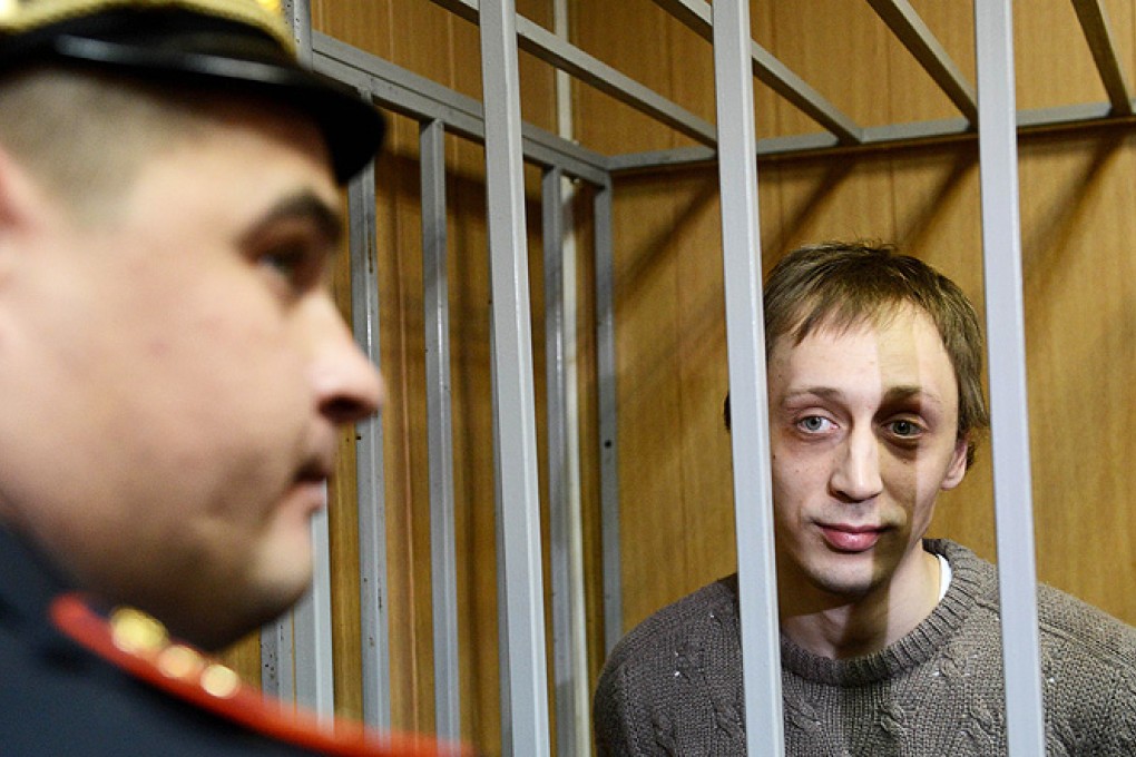 Pavel Dmitrichenko, a leading dancer at Russia’s Bolshoi Theatre, stands inside the defendant's cage during a court hearing in Moscow, on Tuesday. Photo: AFP