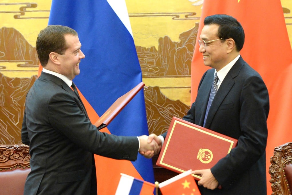 Premier Li Keqiang shakes hands with his Russian counterpart Dmitry Medvedev