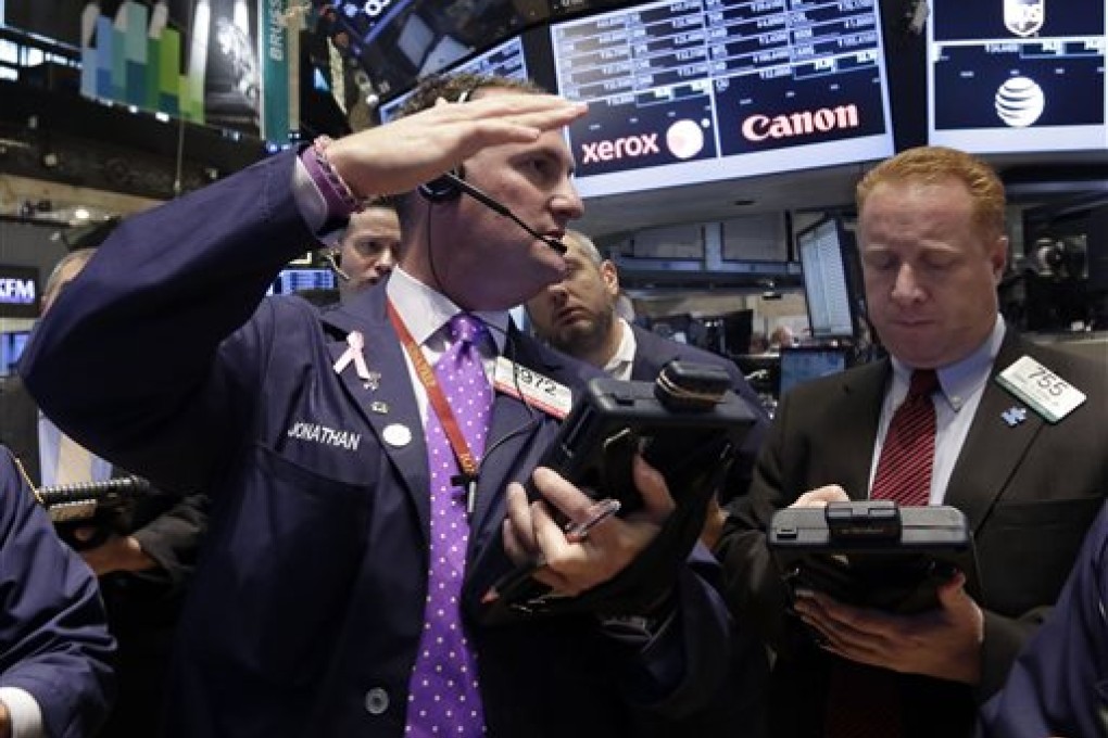 Jonathan Corpina, left, talks with fellow trader Dan Ryan on the floor of the New York Stock Exchange, Friday, Oct. 18, 2013. Stronger economic growth in China and a pickup in U.S. corporate earnings are sending the stock market mostly higher in early trading. (AP Photo/Richard Drew)