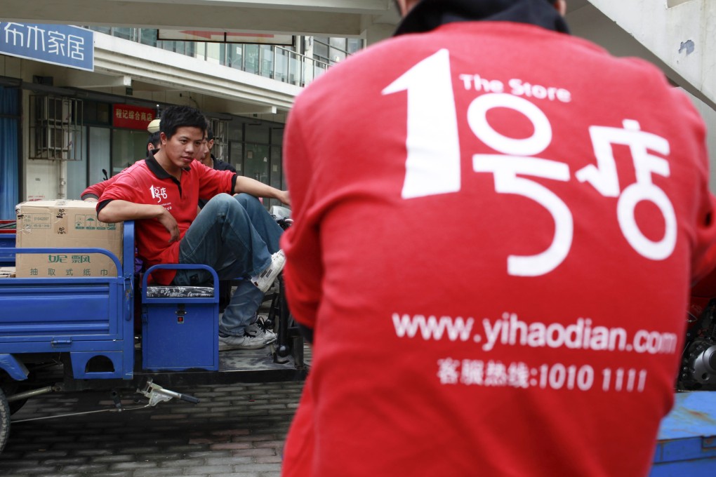 Couriers waiting for the afternoon shipment to arrive relax on their vehicles at a Yihaodian (The Store) distribution branch in Shanghai. Photo: Bloomberg