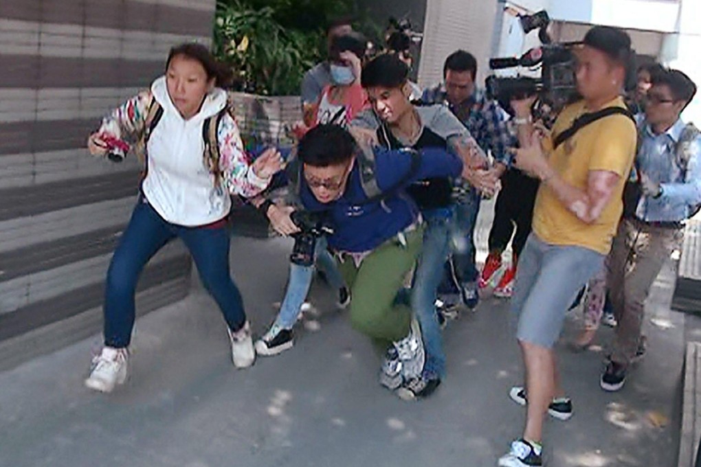 Chioo Wing-ming chases photographer May Tse down the street, knocks her over and kicks her before looming over her outside the Kowloon City Court building. Photo: SCMP