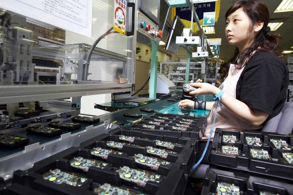 A woman works at a Samsung Electronics' mobile phone assembly line in South Korea. Samsung has been ordered to pay compensation to the family of a worker who died of leukaemia at the age of 29. Photo: Reuters