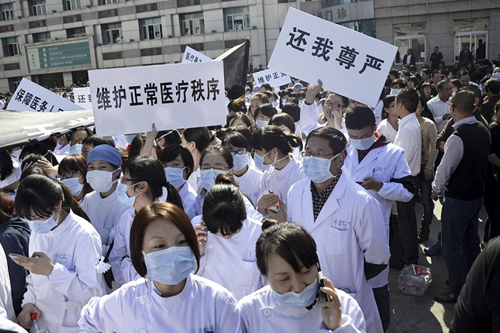 Hospital staff members hold a protest outside the Wenling City No 1 People’s Hospital with signs that read: 'Return my dignity' and 'Maintain normal medical order' in Wenling in eastern China's Zhejiang province on Monday. Photo: AP