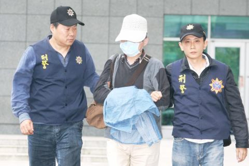 Hsu Wen-tung is escorted by two police officers after arriving in Taiwan. Photo: Central News Agency
