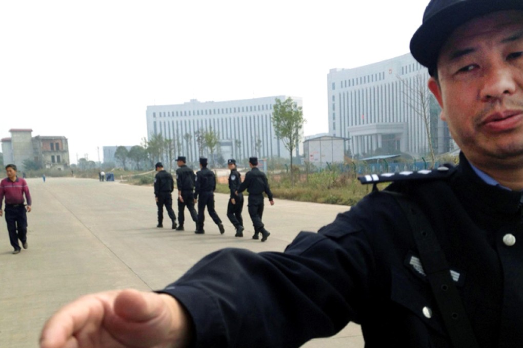 Police shoo journalists away outside Xinyu court. Photo: AP