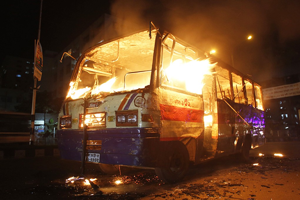 A bus burns on a street in Dhaka on Monday. Photo: Reuters