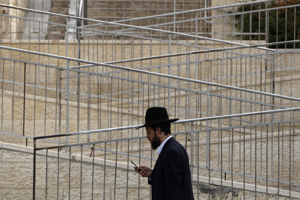 An ultra-Orthodox Jew holds walks through Ramat Shlomo, a  settlement in the occupied West Bank. Photo: Reuters