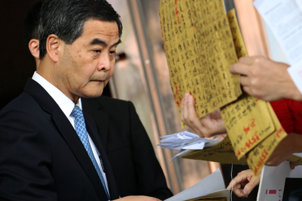 Chief Executive Leung Chun-ying receives petitions outside government headquarters in Admiralty before an Executive Council meeting on Tuesday. Photo: Felix Wong