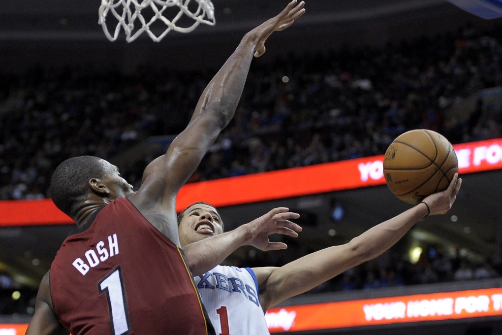 Philadelphia 76ers' Michael Carter-Williams, right, drives past Miami Heat's Chris Bosh to shoot. Photo: AP