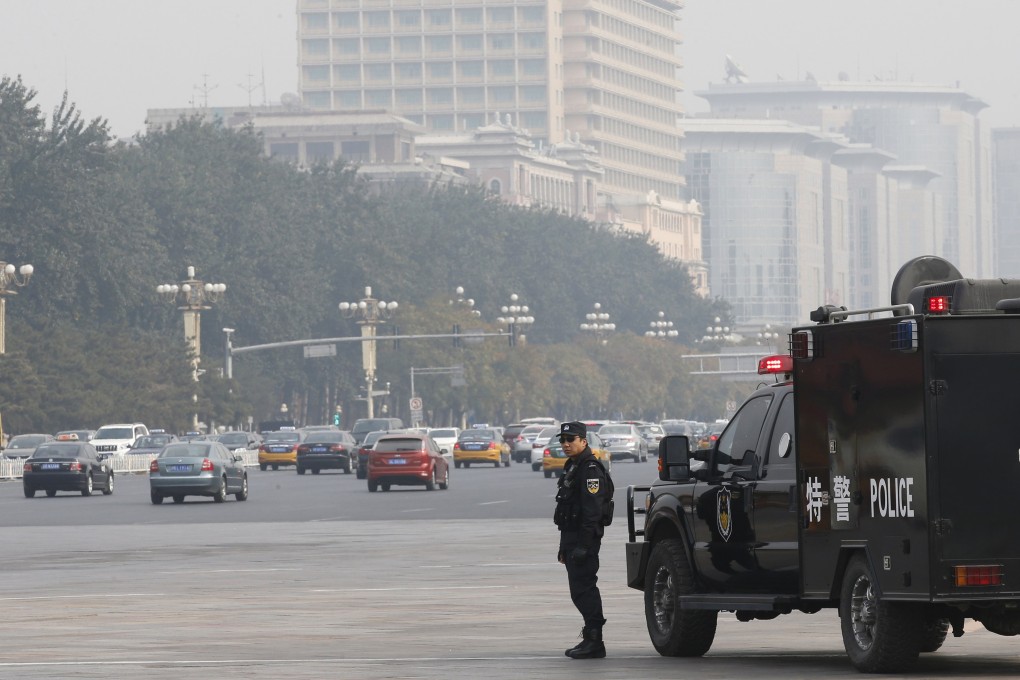 A policeman of the Special Weapons and Tactics team stands guard on a main street next to Tiananmen Square in Beijing. Photo: Reuters