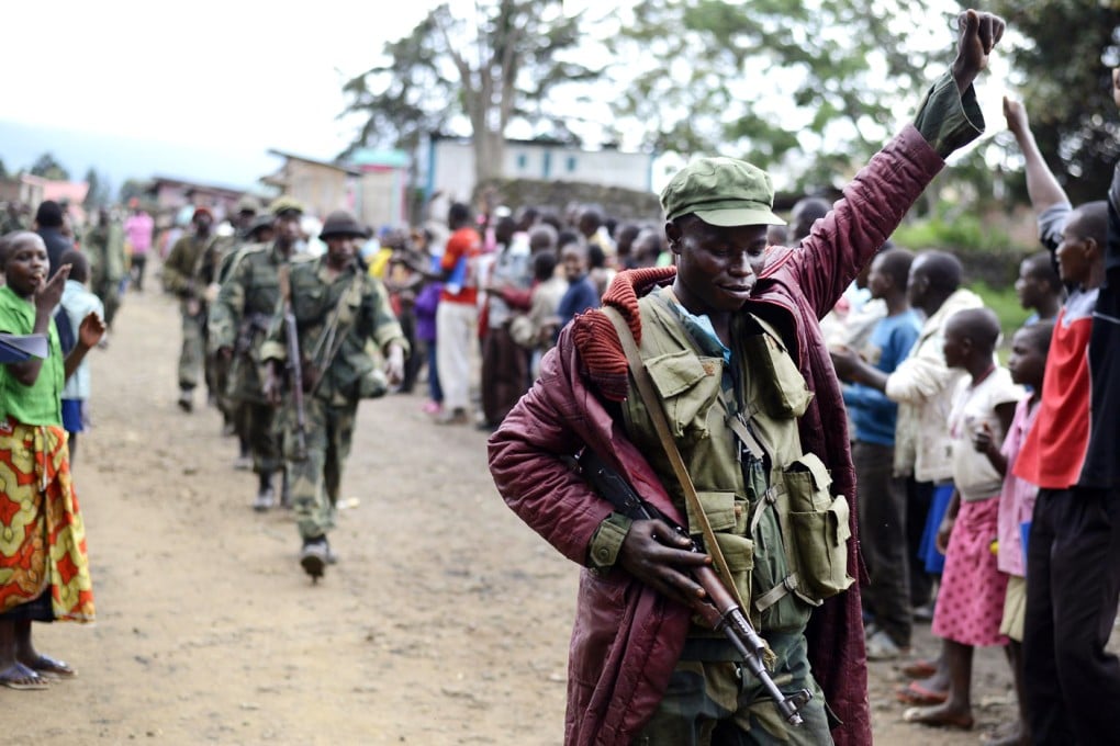 A Congolese soldier responds to cheers from civilians as the army enters the town of Bunagana, which it retook from M23 rebels, as the military sought to extinguish the insurrection. Photo: AP