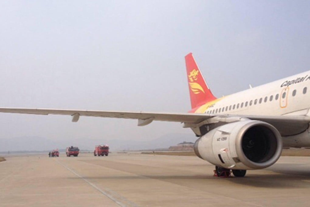 Emergency vehicles approach a Hangzhou-bound Beijing Capital Airlines plane after threats forced it to land at Nanchang airport. Photo: SCMP