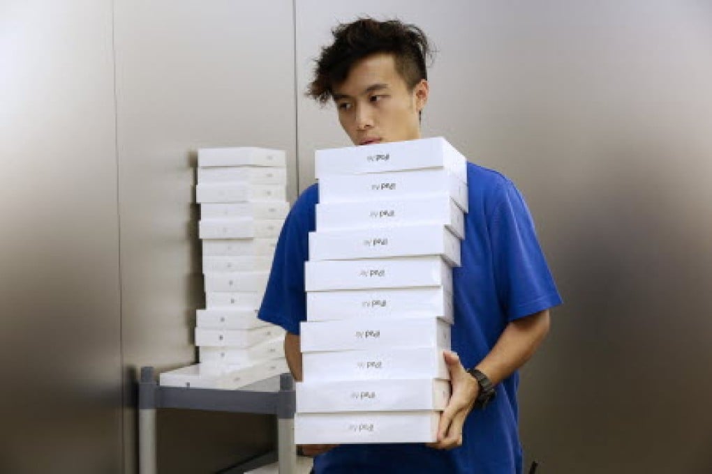 An Apple employee carries boxes containing the new iPad Air at the company's Causeway Bay store in Hong Kong. Photo: Bloomberg