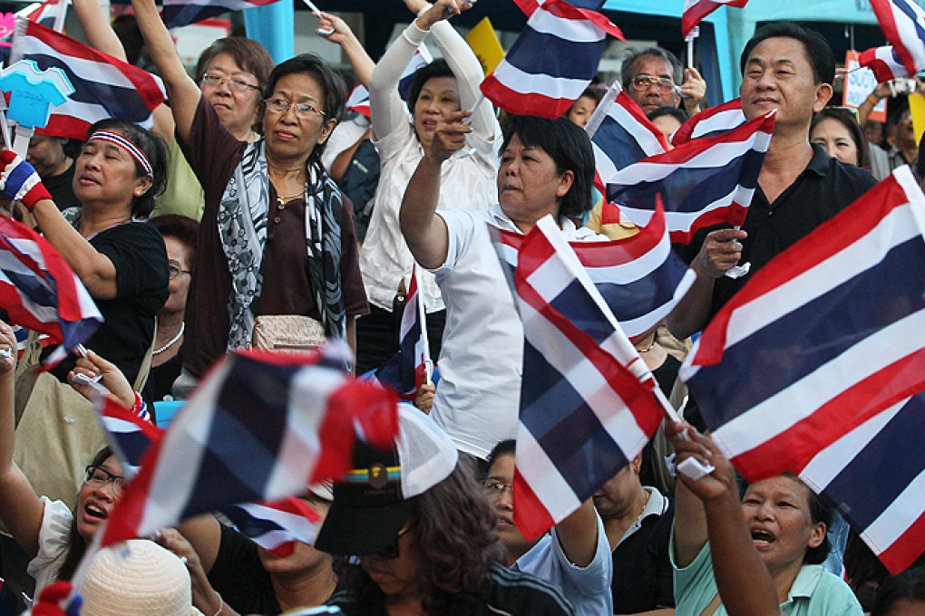 Anti-government protesters wave Thai national flags during a rally against the amnesty bill in Bangkok, Thailand, on Friday. Photo: AP