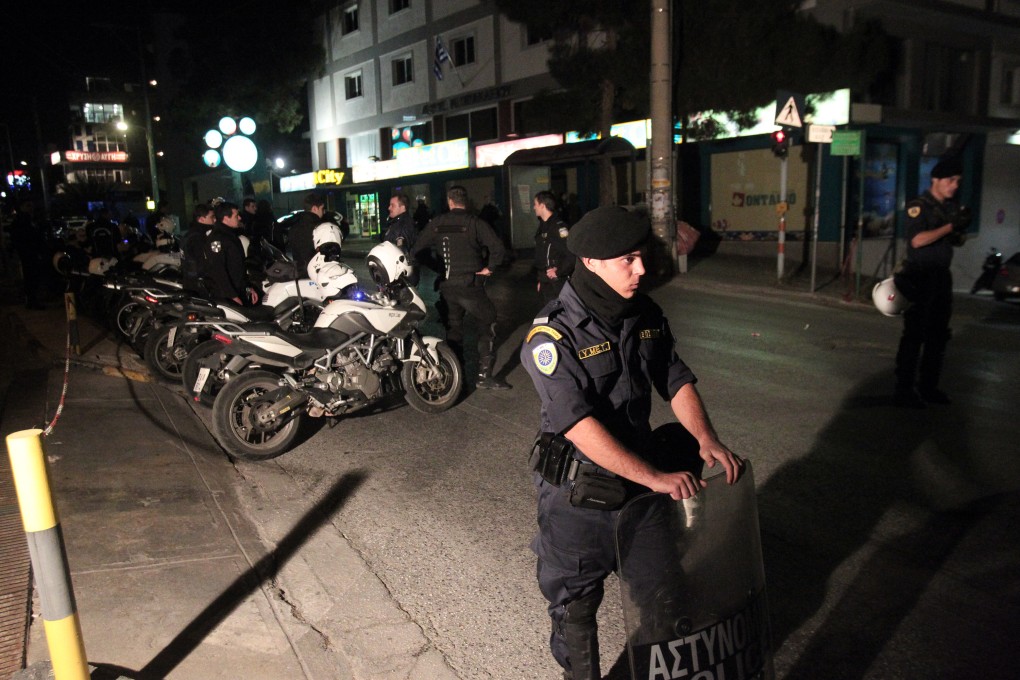 Policemen investigate at the site of the killings in Athens on Friday. Photo: Xinhua