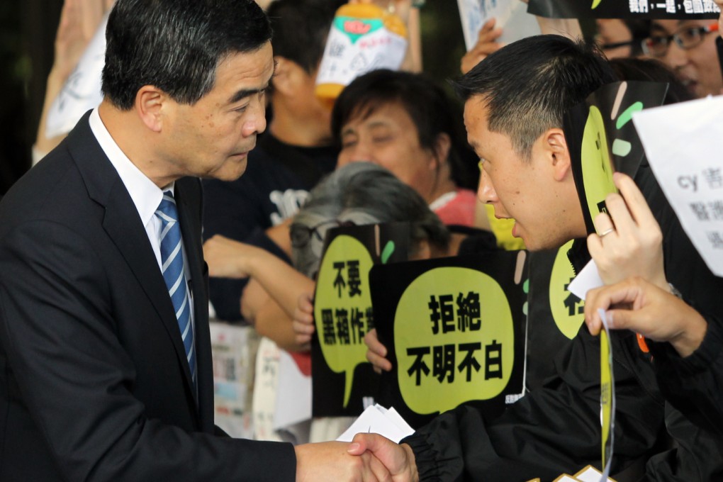 Chief Executive Leung Chun-ying (left) accepts petition letter from HKTV staff union chairman Henry Yeung Chi-ho demanding an explanation on the rejection of HKTV's license application in government headquarters. Photo: Sam Tsang