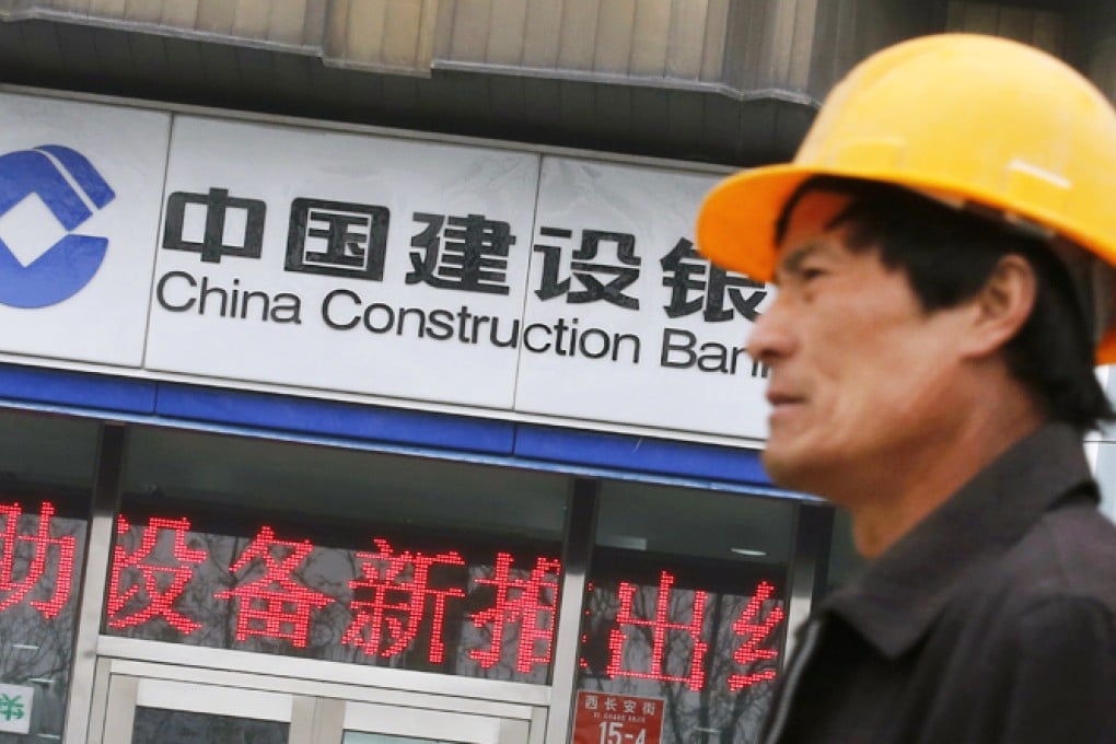 A worker walks past a branch of China Construction Bank (CCB) in Beijing. Photo: Reuters