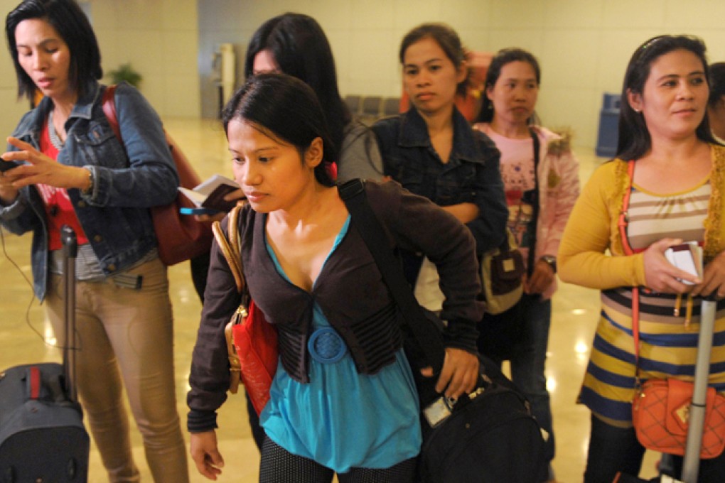 Some of the 30 repatriated Filipino workers arrive at Manila airport. Photo: AFP