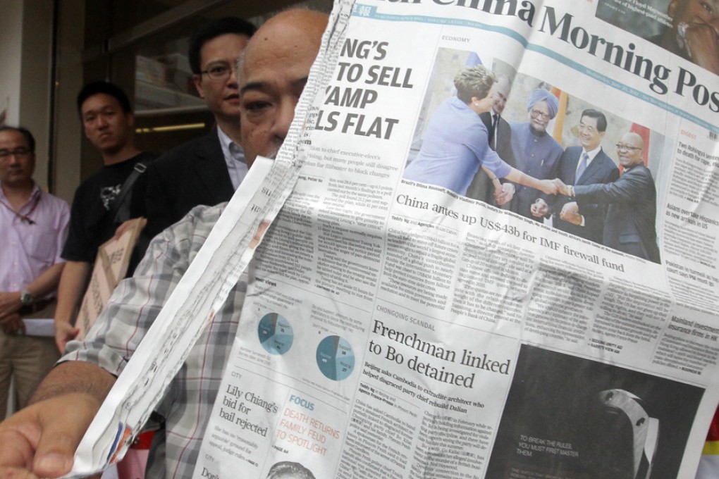 Tsang Kin-shing tears down a copy of South China Morning Post during a protest over the alleged self-censorship on the coverage of the death of mainland activist Li Wangyang in June last year.
