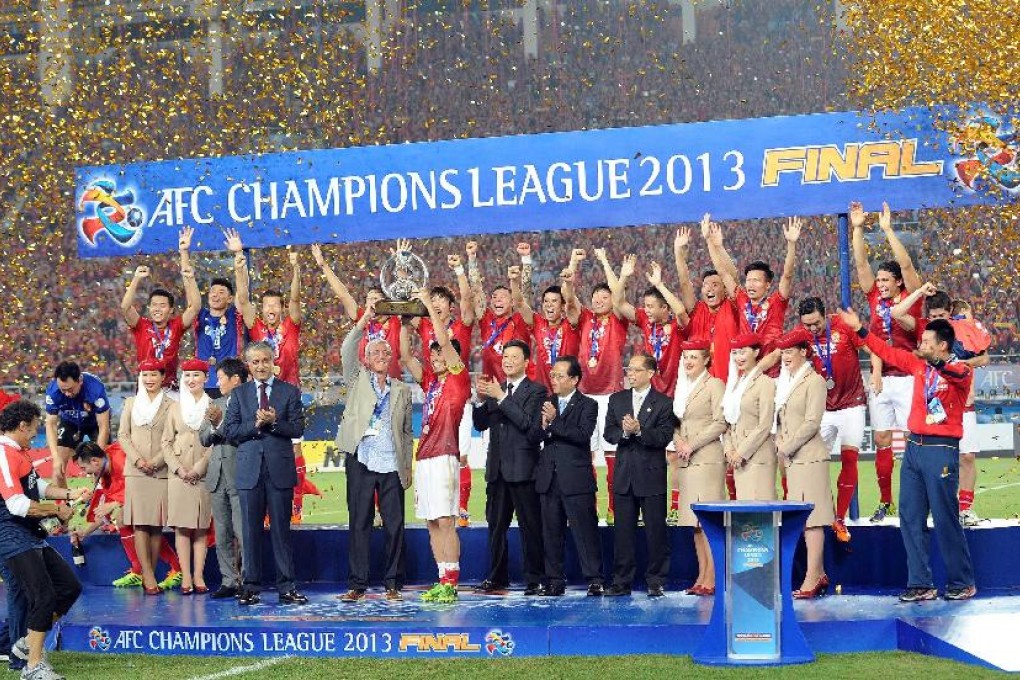 Team members of Guangzhou Evergrande pose for a picture with the trophy after the 2013 AFC Champions League final between Guangzhou Evergrande and FC Seoul in Guangzhou, China. Photo: Xinhua