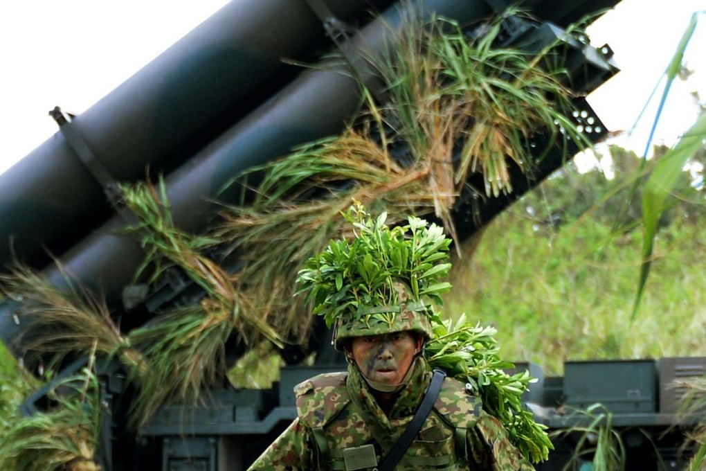 A Japanese soldier helps to prepare surface-to-ship missile launchers during a drill at Camp Naha in Okinawa yesterday. Photo: AFP