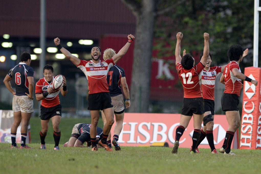 Hong Kong slump to the turf as Japan celebrate at the final whistle during the Singapore final. Photo: SCMP Pictures.