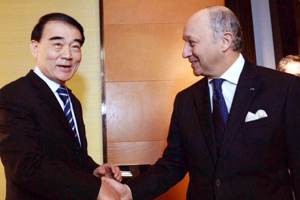 Li Baodong with the French foreign minister. Photo: Xinhua