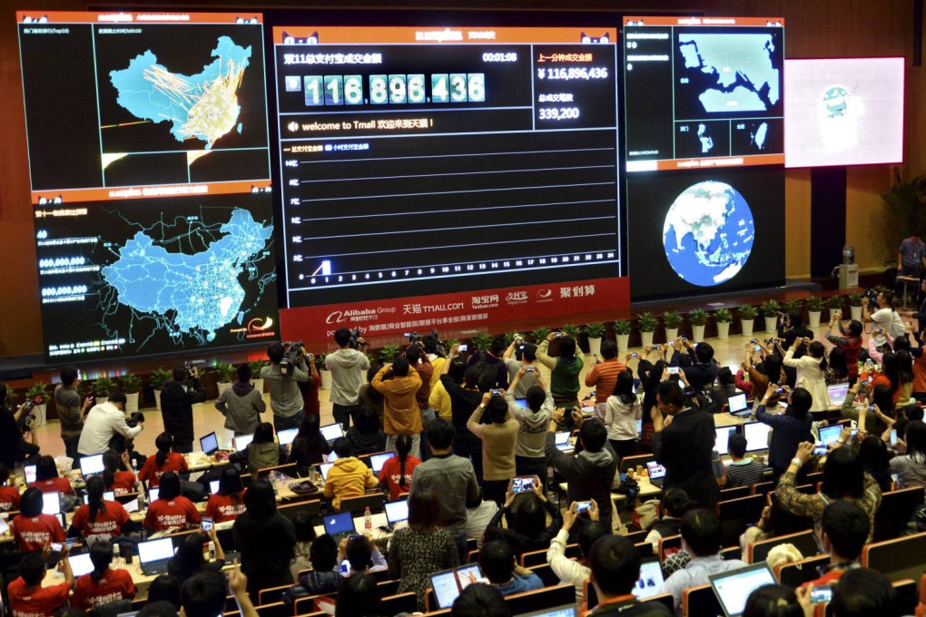 Employees and journalists take pictures and videos of a giant electronic board showing the online transaction value on Alipay, an online payment system of China's leading e-commerce retailers Taobao.com and Tmall.com, at the parent company Alibaba's headquarters in Hangzhou. Photo: Reuters