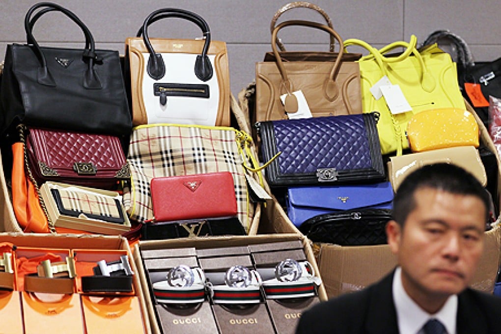 Hong Kong custom's Lui Tze-cheuk briefs the media on the increasing number of seizures of counterfeit goods. Photo: Nora Tam