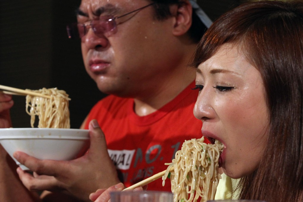 Johnny Wu (left) and Tomoko Miyake battle to be ramen champion at the contest in Kowloon Bay yesterday. Photo: Nora Tam
