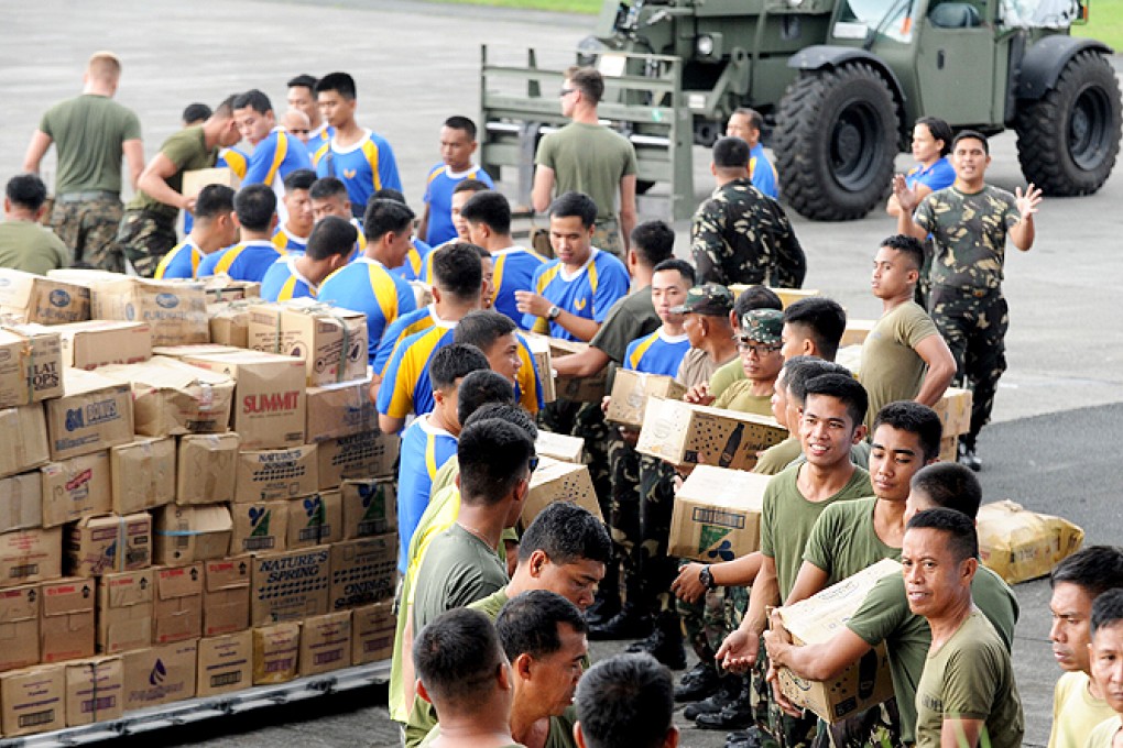 US and Philippine military personnel prepare relief goods for transporting at the military base in Manila on Monday. Photo: AFP