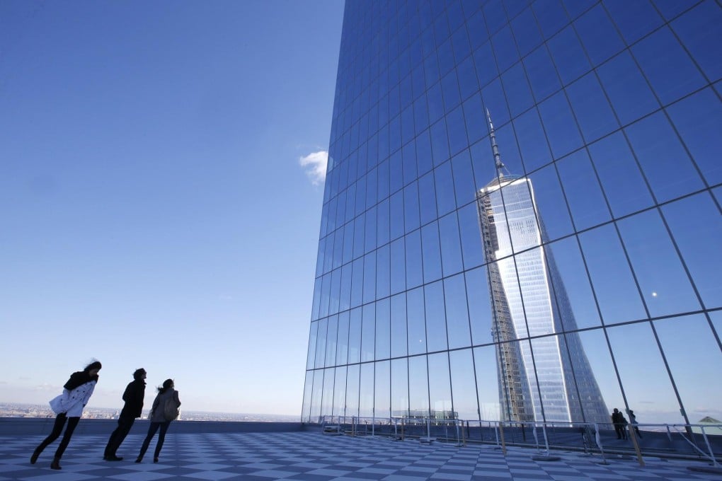 Tourists look up at the reflection of the One World Trade Centre tower - ruled the highest building in the US - from a terrace on the 57th floor of the soon-to-be-opened 4 World Trade Centre tower. Photo: Reuters