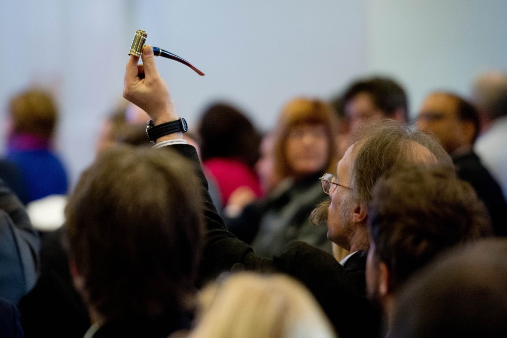 A delegate holds up his e-pipe at the E-cigarette Summit at the Royal Academy in London. Photo: AFP