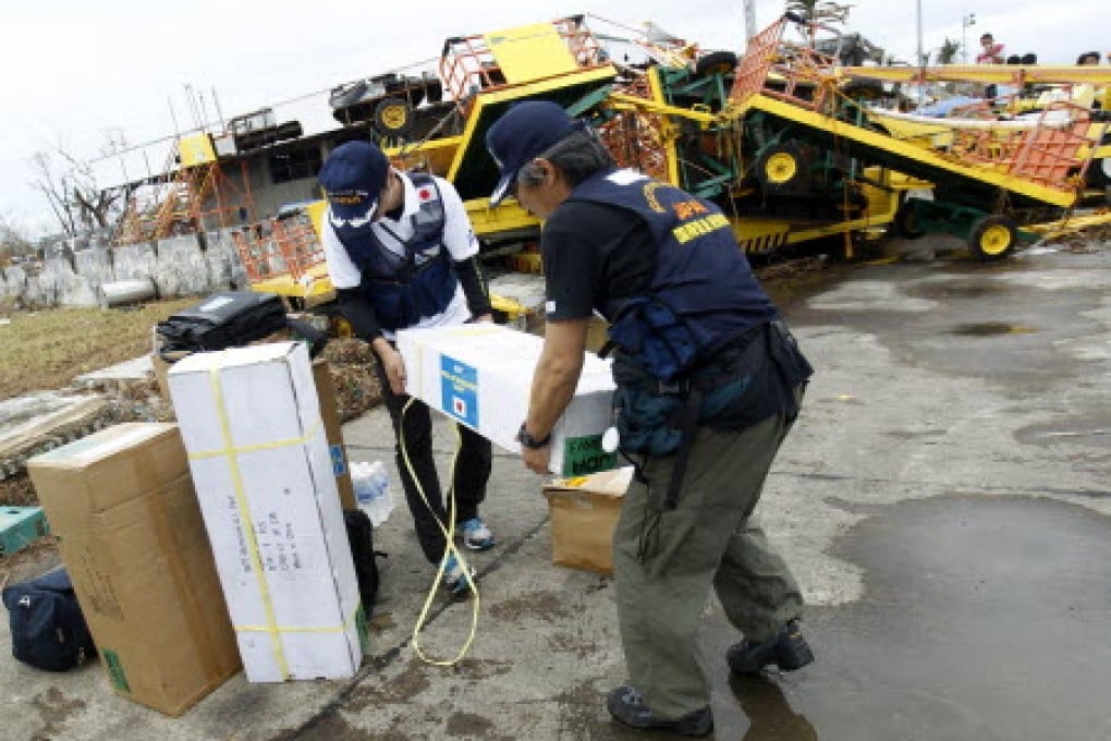 A member of Japan's Disaster Relief Team moves supplies after arriving at the airport in Tacloban. Photo: Reuters