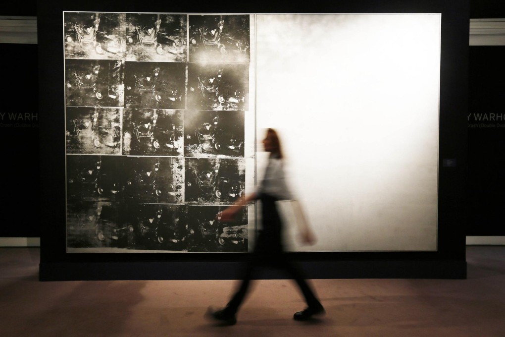 A Sotheby's employee walks past the record-breaking Andy Warhol painting Silver Car Crash (Double Disaster). Photo: Reuters