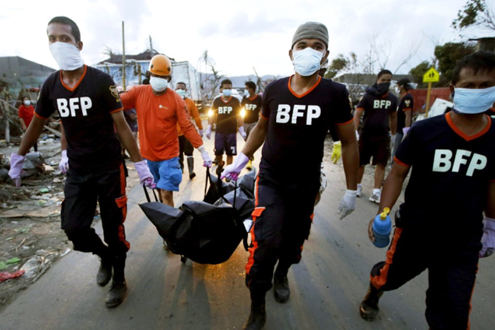 Firemen carrying the body of a victim in Tacloban. Photo: AP