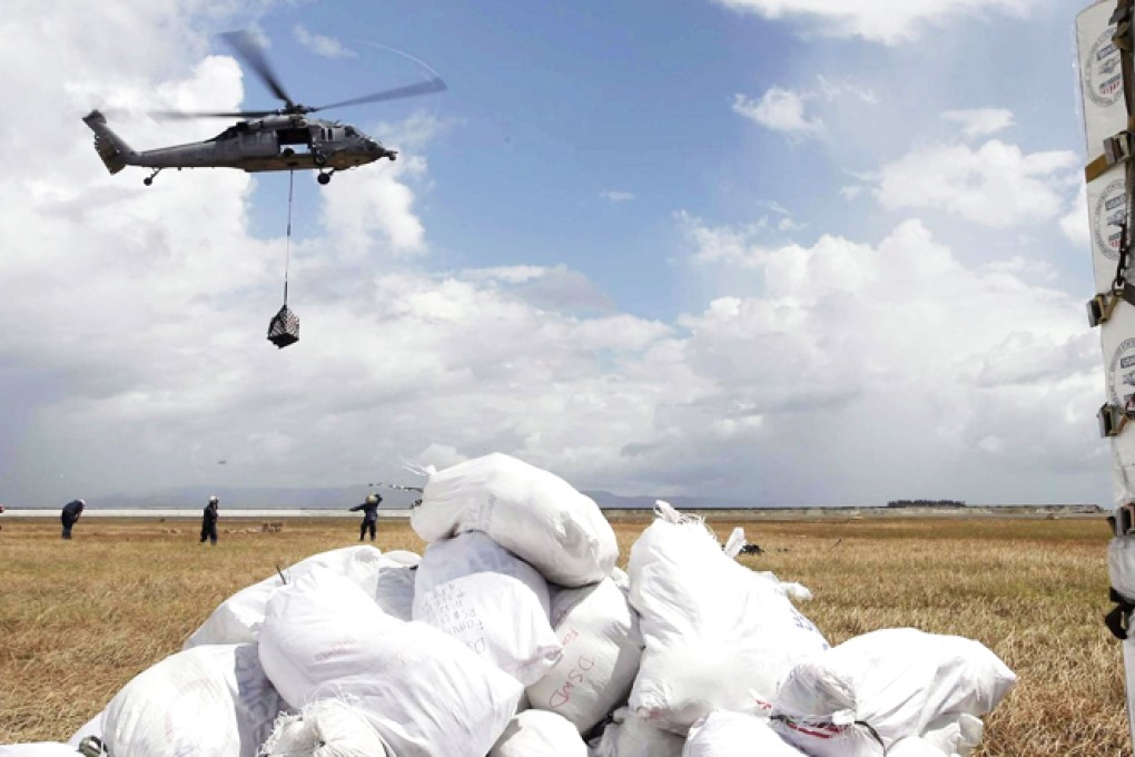 Personnel from the US navy wait for the Blackhawk helicopters transporting boxes of bottled water near the city of Tacloban in the Philippines, which has been devastated by the super typhoon that hit on Friday. Photos: EPA