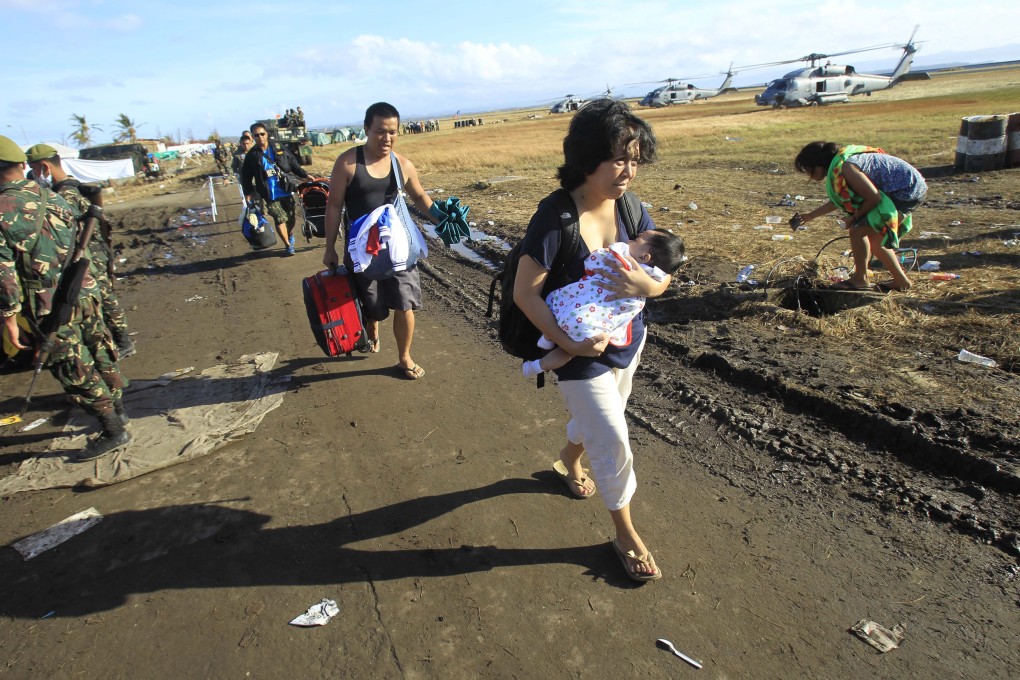 Survivors walk to an evacuation flight at Tacloban airport. Photo: AP