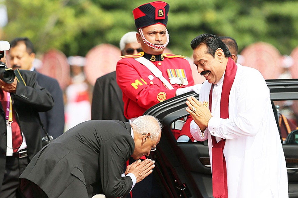 Sri Lankan President Mahinda Rajapakse (right) greets his secretary as he arrives at the opening session of the Commonwealth Heads Of Government Meeting 2013, at the Nelum Pokuna Mahinda Rajpaksa Theatre in Colombo on Friday. Photo: AFP