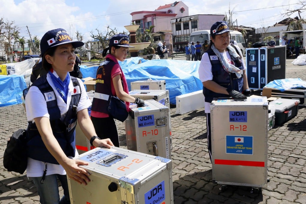 Japanese rescue team prepare their gear as they set up field hospital in the downtown of Tacloban City. Photo: EPA