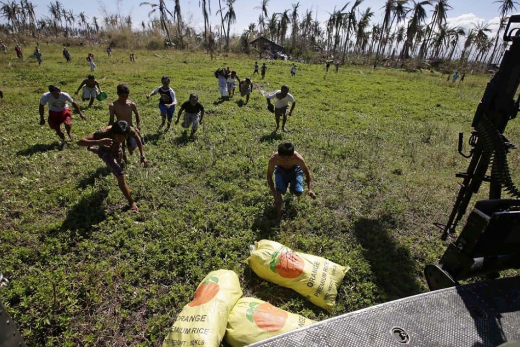 Typhoon survivors rush to grab sacks of rice delivered by the Philippine army in devastated Leyte province yesterday. Photo: EPA